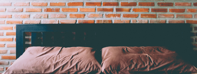 bed with exposed brick wall